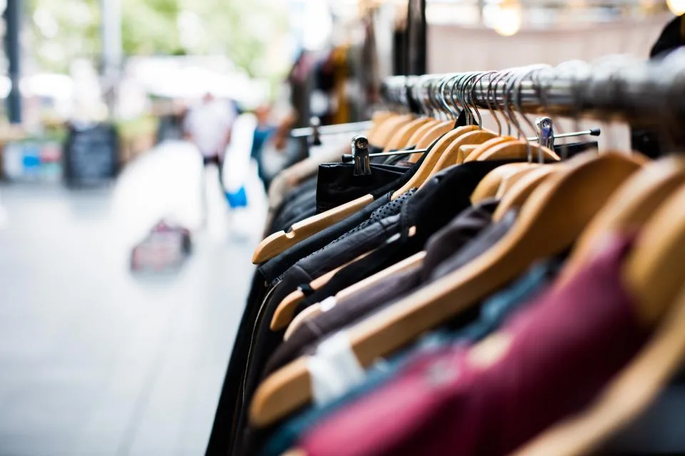 Clothes on wooden hangers on a rack